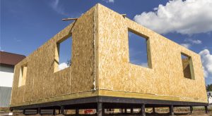 Home construction made of plywood with blue sky behind