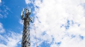 Image of cell tower with cloudy but bright blue sky in the background