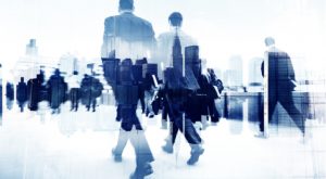 business people walking on a busy street overlaid with a city in the backdrop