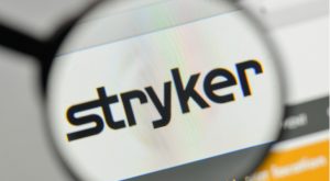 the Stryker (SYK) logo on a web browser enlarged by a magnifying glass