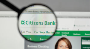 A magnifying glass zooms in on the website for Citizens Bank (CFG).