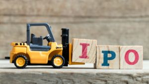 a toy forklift picking up wooden blocks that spell out "IPO"