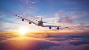 Image of a plane flying in the sky representing airline stocks