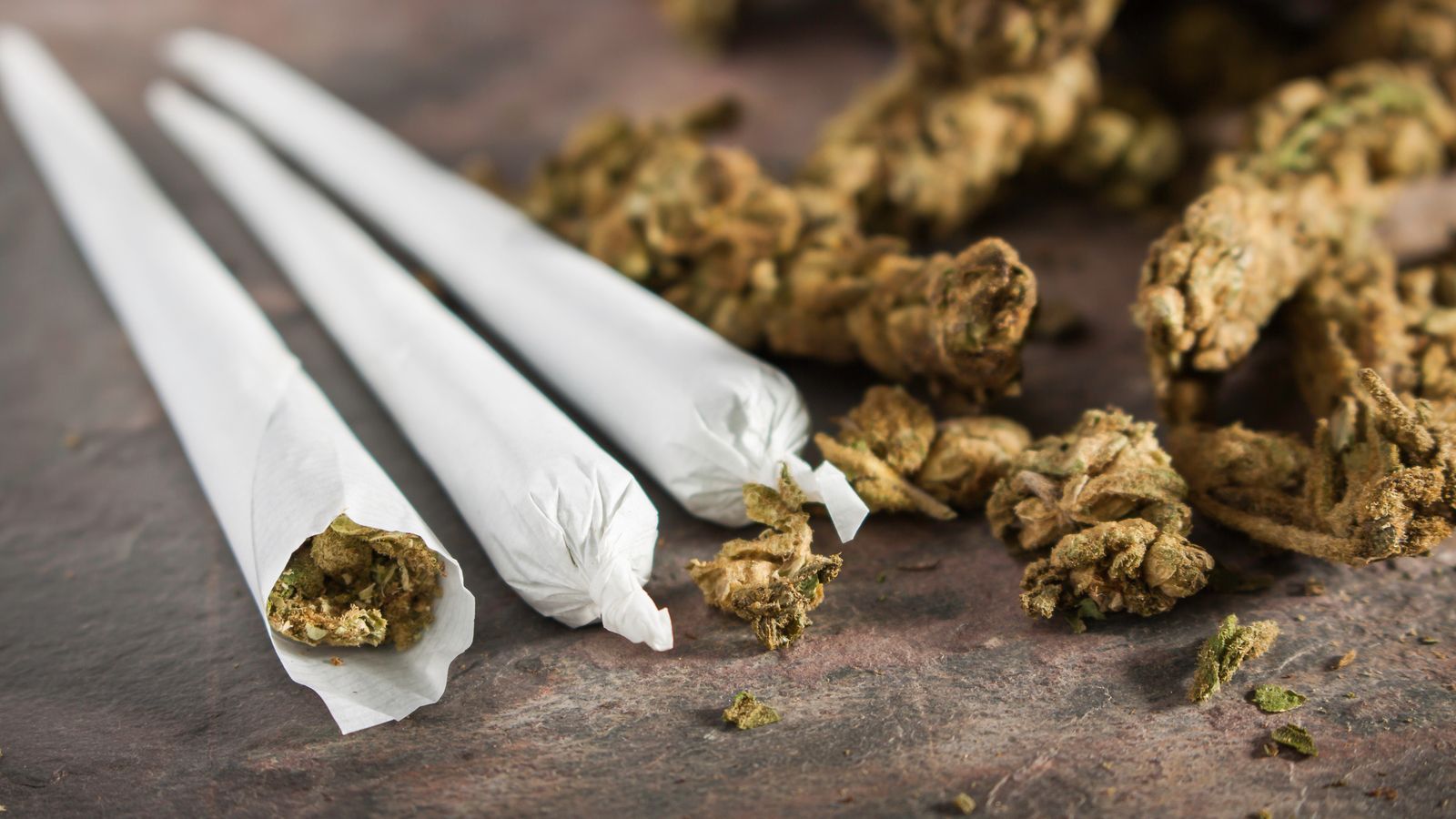 Image of marijuana alongside three joints representing cannabis stocks.