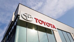 Le logo de Toyota (TM) sur le bâtiment d'un concessionnaire à la lumière du jour