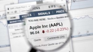 Apple (AAPL) stock information in a magnifying glass.