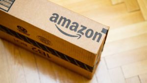 photo of an Amazon (AMZN) box on wood floor of home