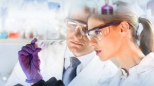 Image of two scientists in lab coats studying results in a lab