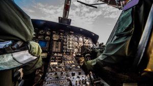 the cockpit of a plane with two pilots sitting in it