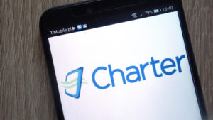 The Charter Communications (CHTR) logo is displayed on a smartphone screen. 