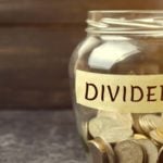 Glass jar of coins marked "dividends" to represent dividend stocks. dividend stocks for passive income. dividend stocks