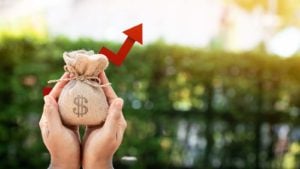 image of hands holding small money bag symbolizing dividend stocks. Stocks That Could Turn $100 into $1,000