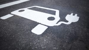 White chalk on pavement shows a plug-in electric vehicle.