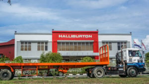 photo of Halliburton (HAL) logo in red on building with truck in front