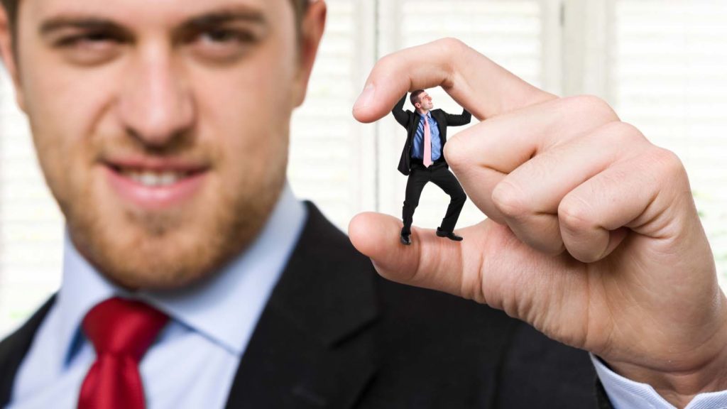 A giant business man crushing a smaller businessman between his fingers