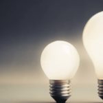 energy stocks to buy: two light bulbs with grey sky in the background