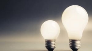 energy stocks: two light bulbs with grey sky in the background