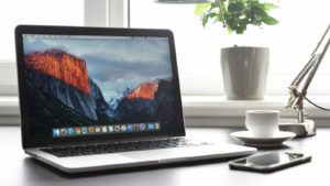 a macbook on a desk representing apple stock (AAPL)