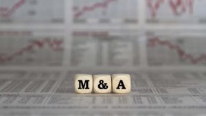 "M&A" dice rest on paper background.