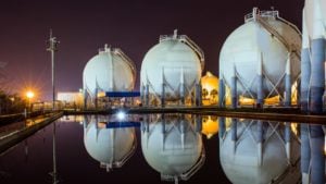 TELL stock: a row of natural gas tanks pictured in the evening. Natural gas stocks