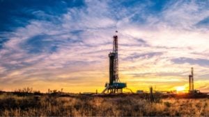 photo of large oil well infrastructure in a field at sunset