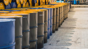a pile of oil barrels are stacked high