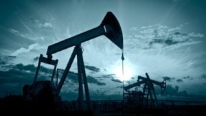 Image of an oil wells with a dark blue sky representing Oil Price Predictions.