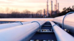 close up of oil pipelines at sunset representing CEI stock.