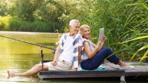 Retired couple sitting on dock in water