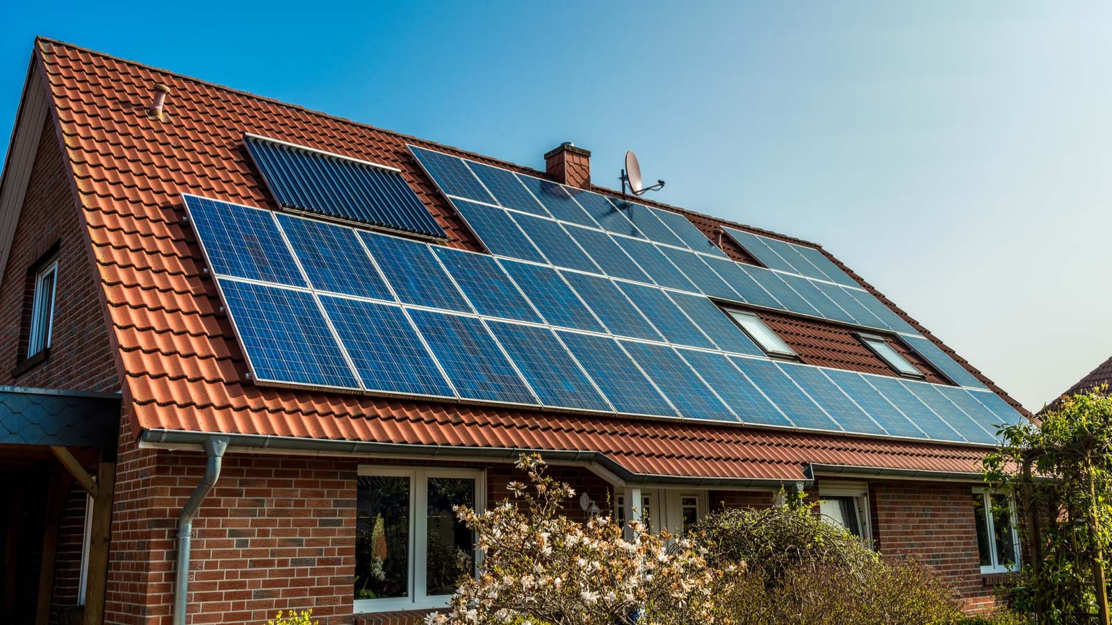 An orange slanted roof covered in solar panels representing STEM stock.