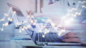 A graphic of a person's hands resting on a laptop with a stock line graph moving through it representing Nancy Pelosi Stocks.