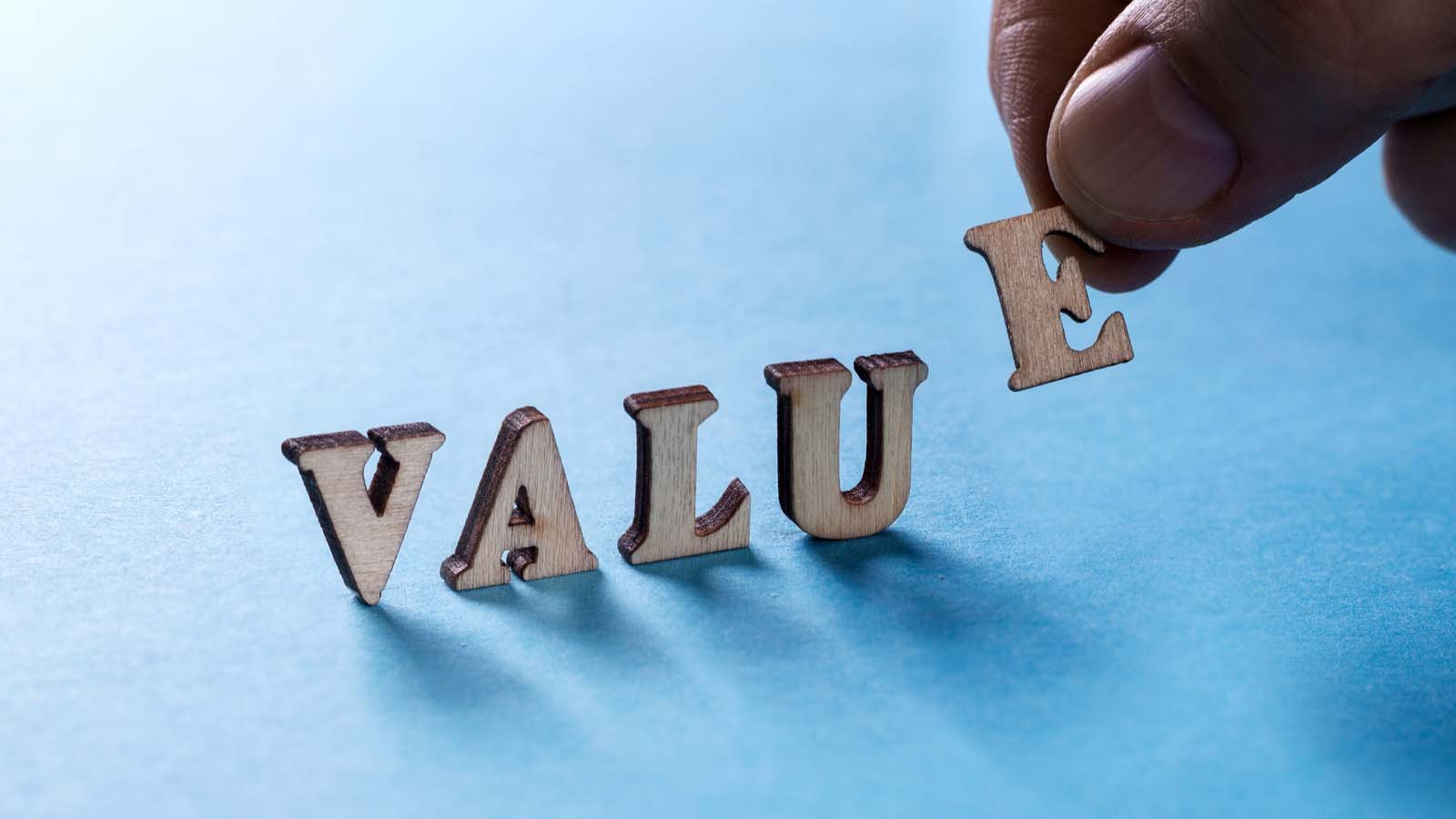 Wooden letters spell out "VALUE."