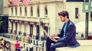 Man at Wall Street on laptop.