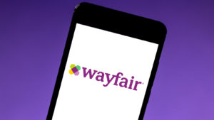 The Wayfair (W) logo on the screen of a mobile phone with a purple background