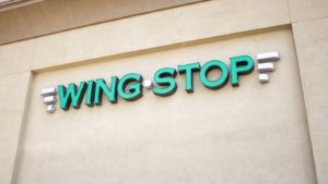 The logo for Wingstop is displayed on a building wall.