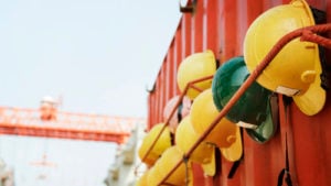 hard hats hung up at a construction site symbolizing safety, labor and construction. Safe stocks to buy.