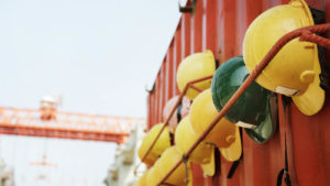 hard hats hung up at a construction site symbolizing safety, labor and construction. Safe stocks to buy.