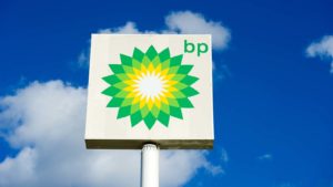 the BP (BP) logo on a sign against a blue sky with clouds