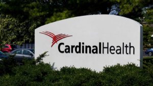 Cardinal Health (CAH) sign with bushes in front of it