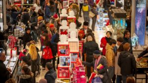 a busy shopping center with numerous customers looking at various products on display