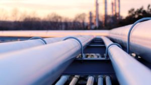 A close-up shot of pipelines with a setting sun in the background.