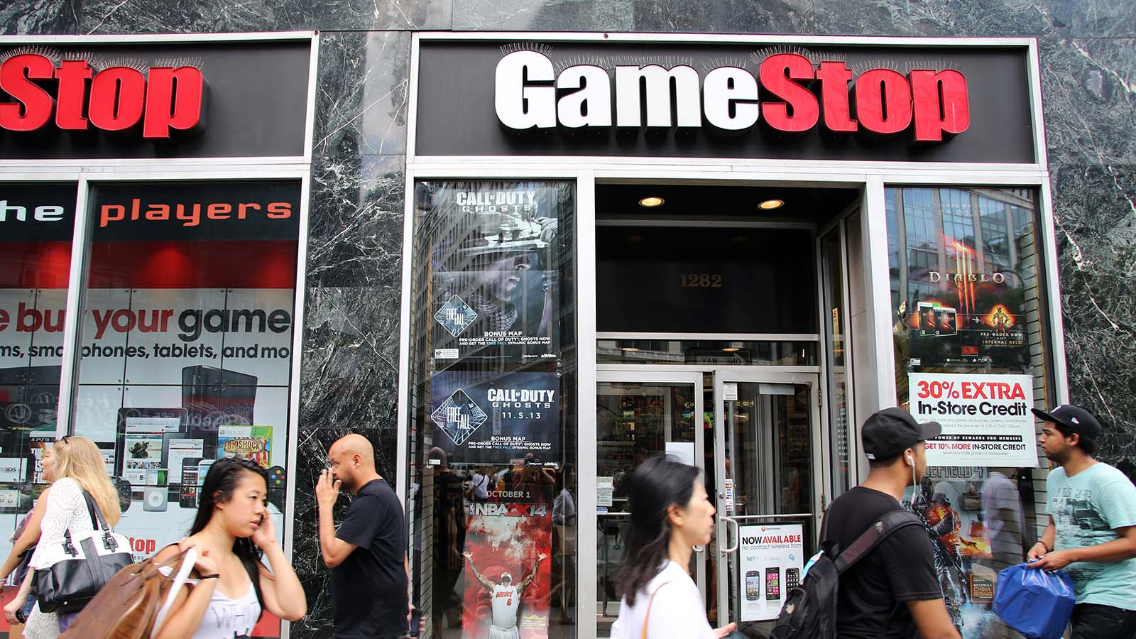 Retailers walk past a GameStop (GME stock) store in New York City, New York.