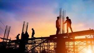 workers on a construction site with the sun setting in the background