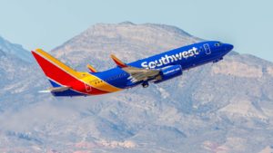 Southwest (LUV) plane mid-flight with mountains in background. Represents airline stocks.