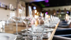 Restaurant Stock: Wine glasses, cutlery, and plates on a long table