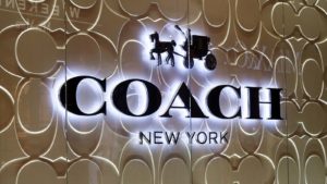 Image of a Coach sign with lights behind it