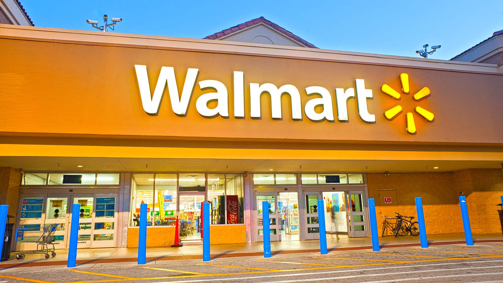 Walmart sign on front of Walmart store at sundown representing wmt stock