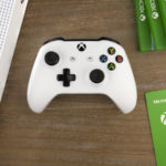 Image of an Xbox One Controller and other products on a wooden surface.