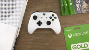 Image of an Xbox One Controller and other products on a wooden surface.