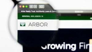 虫眼鏡で拡大された、Web ブラウザー上の Arbor Realty Trust (ABR) のロゴ